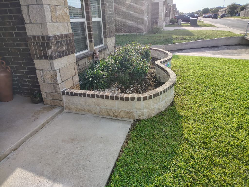 Curved stone planter bed built around home corner