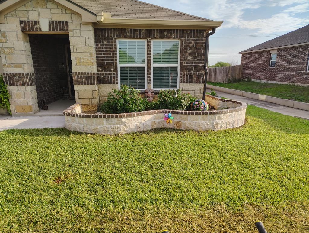 Curved stone flower bed wall along front of San Antonio home