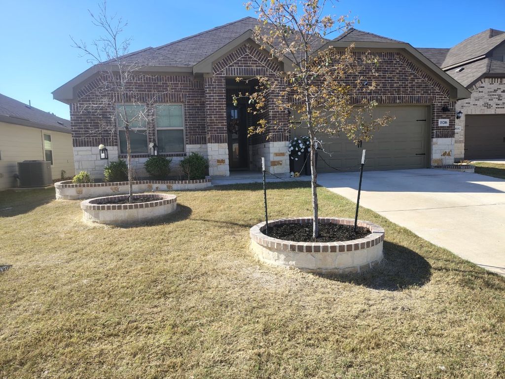 Custom round stone tree planters installed in San Antonio front yard